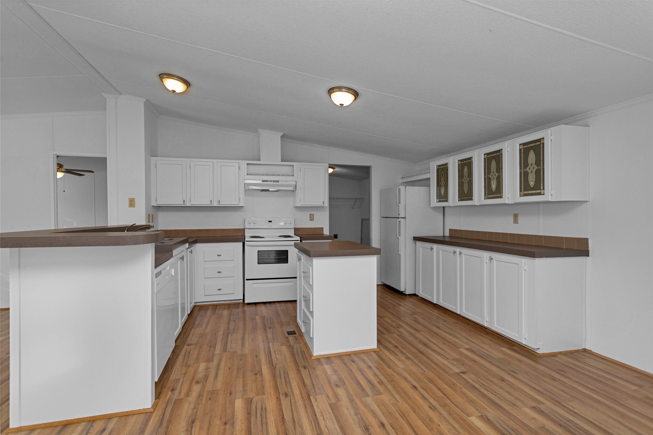 16426 Trenda Court Conroe, TX 77306 - Photo 11 of 35 a kitchen with wooden floors and white counter