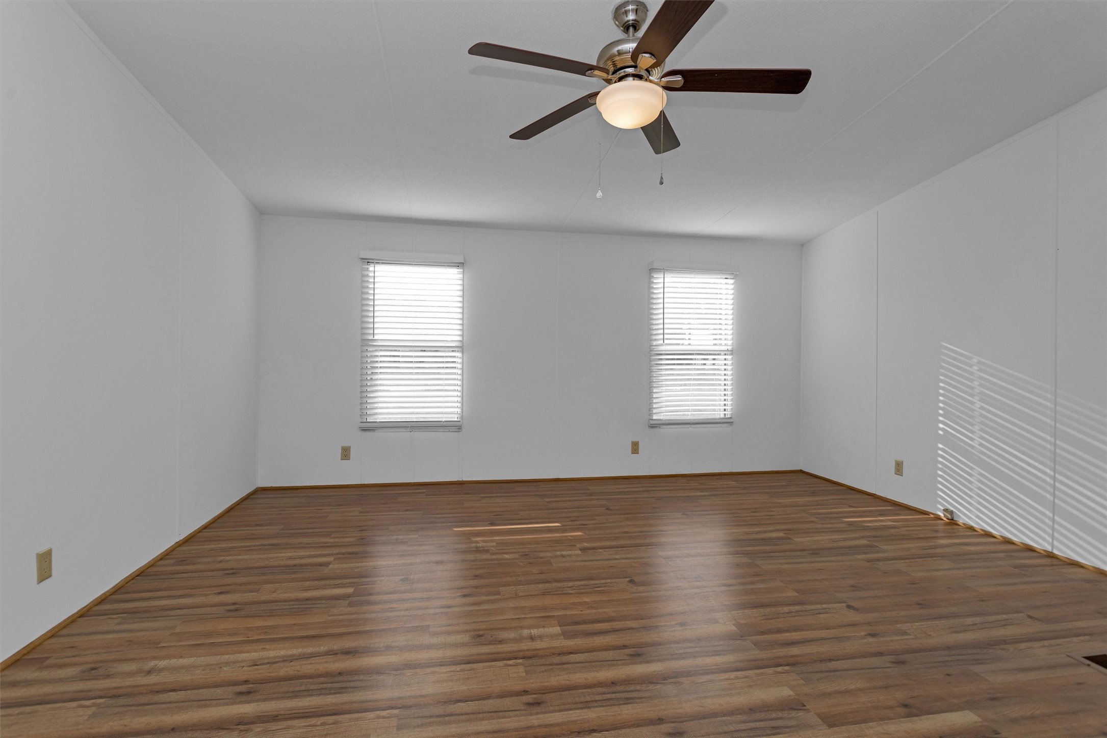 16426 Trenda Court Conroe, TX 77306 - Photo 19 of 35 an empty room with wooden floor ceiling fan and windows