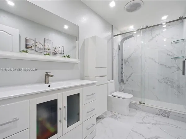 a bathroom with a sink toilet and shower