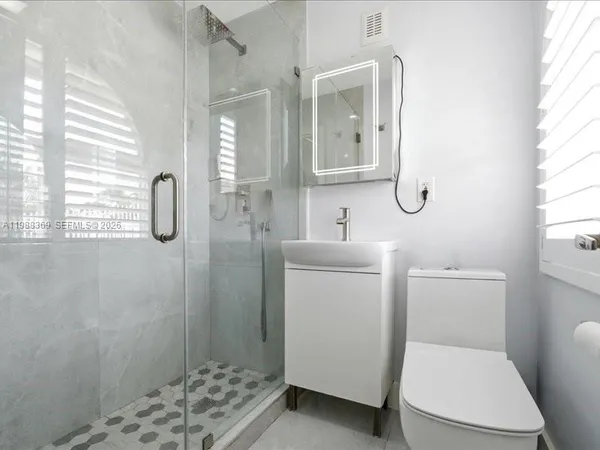 a bathroom with a toilet sink and shower