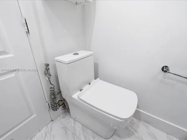 a white toilet sitting next to a shower