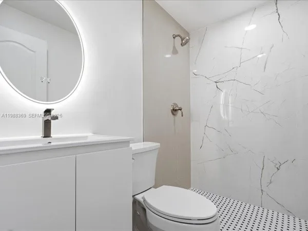 a white toilet sitting next to a bathroom sink