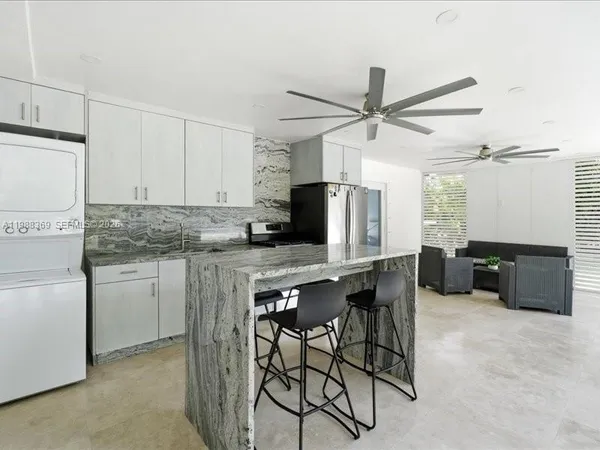 a kitchen with stainless steel appliances granite countertop a stove a refrigerator and a refrigerator with white cabinets