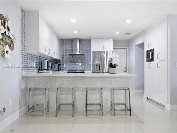 a kitchen with cabinets and chairs