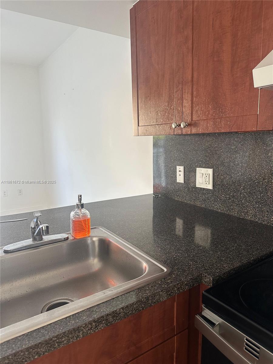 1020 Southwest 4th Street, Unit 106 Miami, FL 33130 - Photo 2 of 10 a kitchen with granite countertop a sink and cabinets