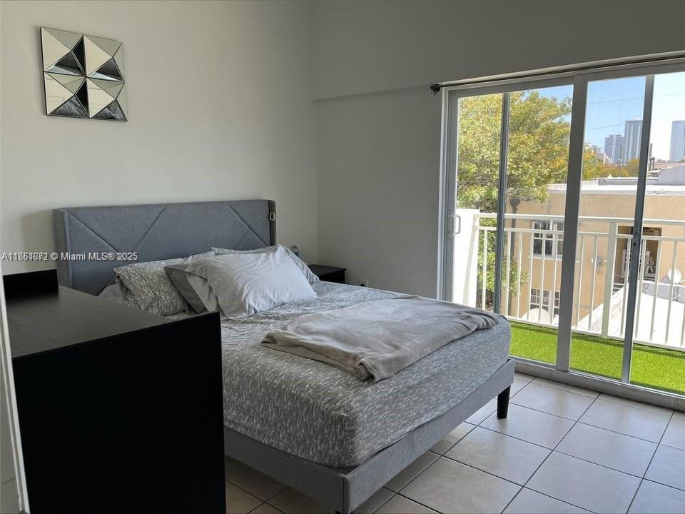 1020 Southwest 4th Street, Unit 106 Miami, FL 33130 - Photo 5 of 10 a bedroom with a bed and a large window