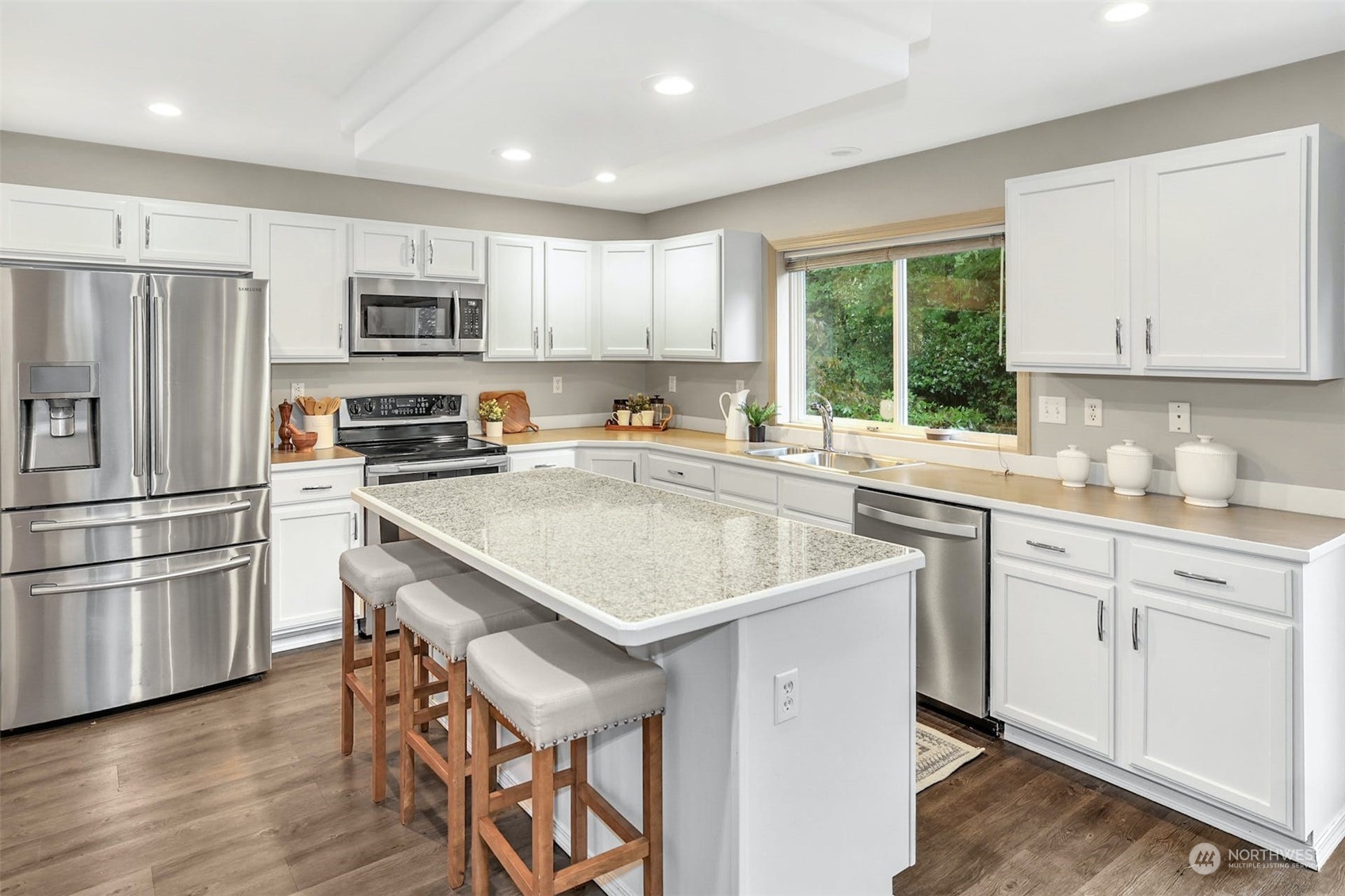 10413 Southeast 186th Place Renton, WA 98055 - Photo 10 of 34 a kitchen with stainless steel appliances granite countertop a sink a stove a refrigerator cabinets and a window