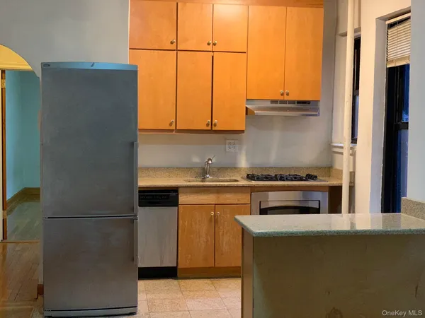 a kitchen with stainless steel appliances white cabinets and a refrigerator