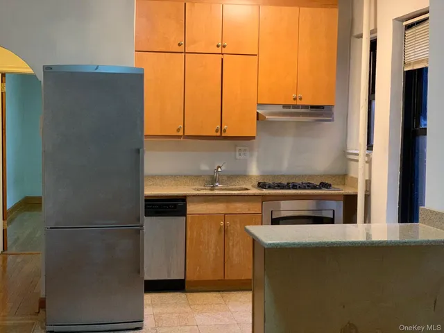 a kitchen with stainless steel appliances white cabinets and a refrigerator