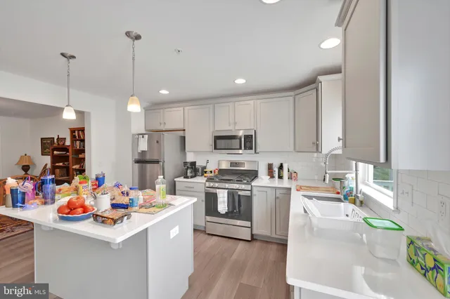 a kitchen filled with stainless steel appliances kitchen island granite countertop a sink stove and refrigerator
