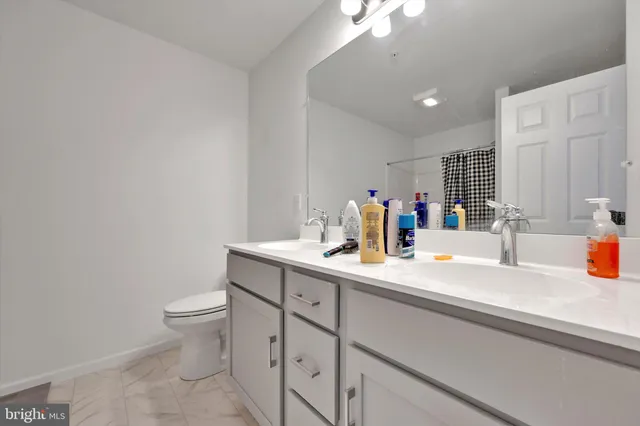 a bathroom with a sink a toilet and a mirror