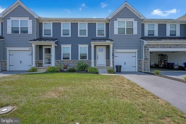 a view of a brick house with a yard and large windows
