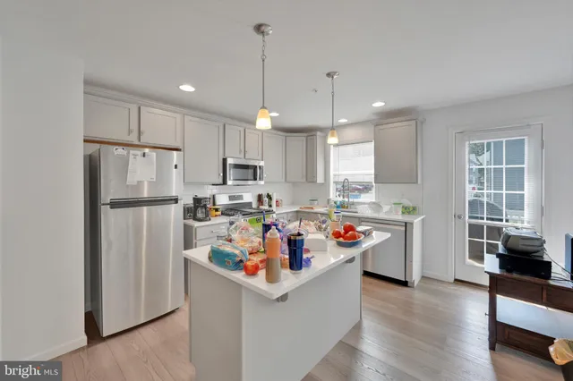a kitchen with stainless steel appliances granite countertop a refrigerator a sink and a stove