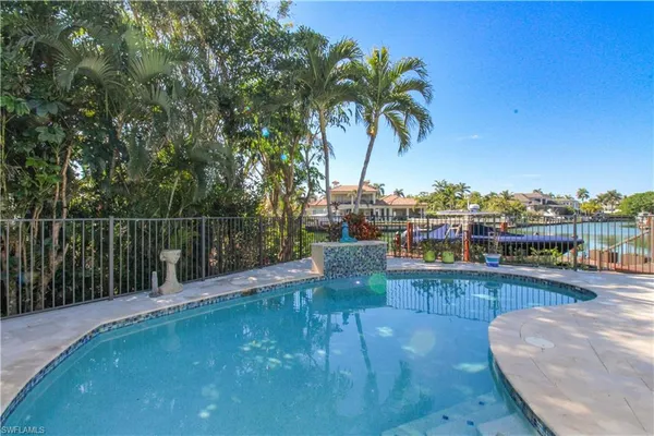 a view of a swimming pool with a patio and ocean view
