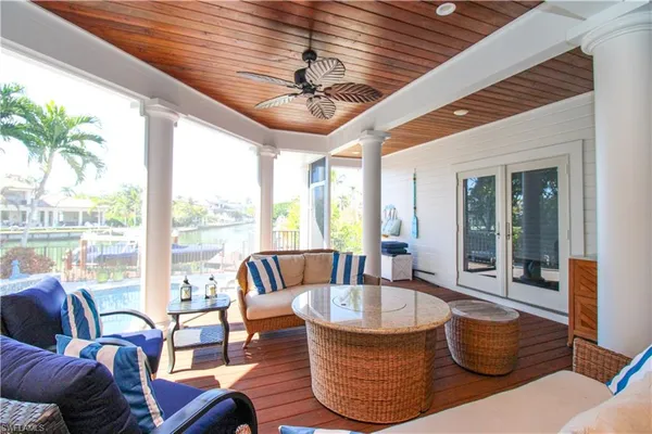 a living room with patio furniture and a large window
