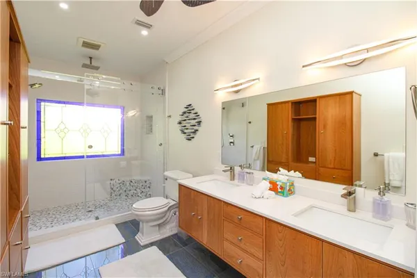 a bathroom with a double vanity sink mirror and toilet