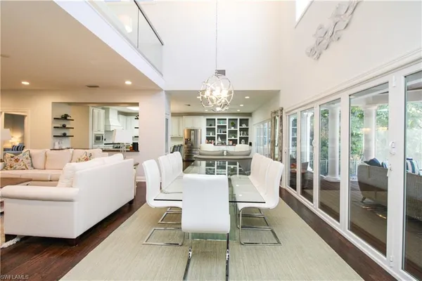a view of a dining room with furniture large windows and wooden floor