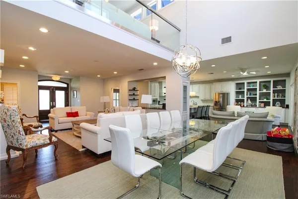 a living room with dining table and a chandelier