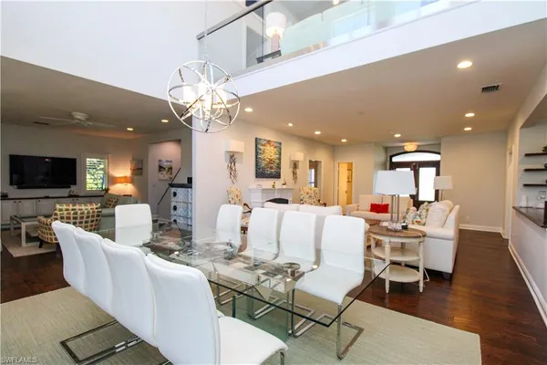 a living room with furniture kitchen view and a chandelier