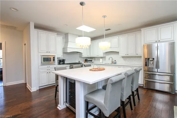 a kitchen with kitchen island granite countertop a sink a center island and stainless steel appliances