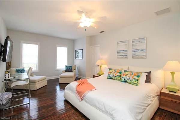 a bedroom with a bed wooden floor and window