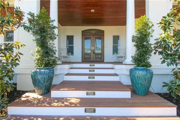 a front view of a house with potted plants