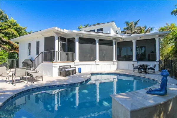 a view of a house with swimming pool and sitting area