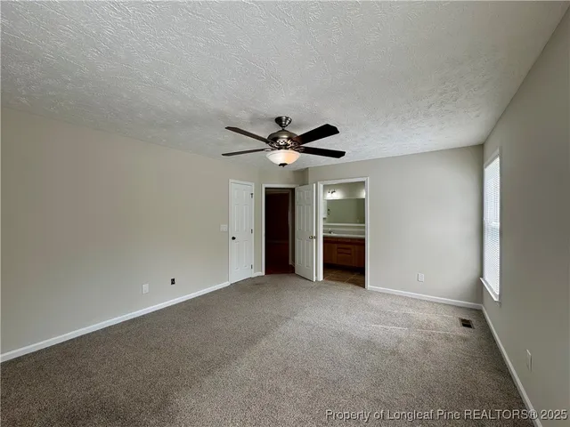 a view of a livingroom with a ceiling fan and window