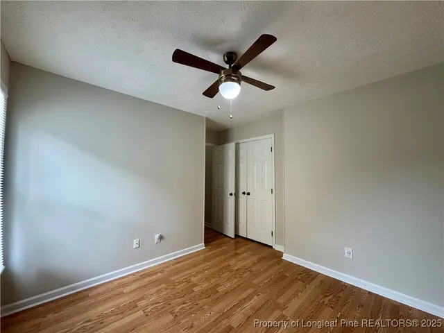 a view of a big room with wooden floor and windows