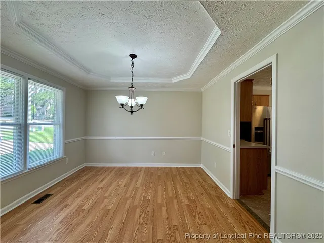 a view of a room with wooden floor exposed radiator and windows