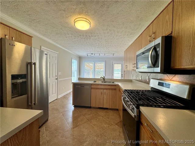 a kitchen with stainless steel appliances granite countertop a stove a sink dishwasher a refrigerator and a microwave