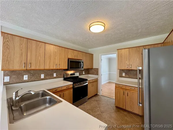 a kitchen that has a sink and a stove top oven
