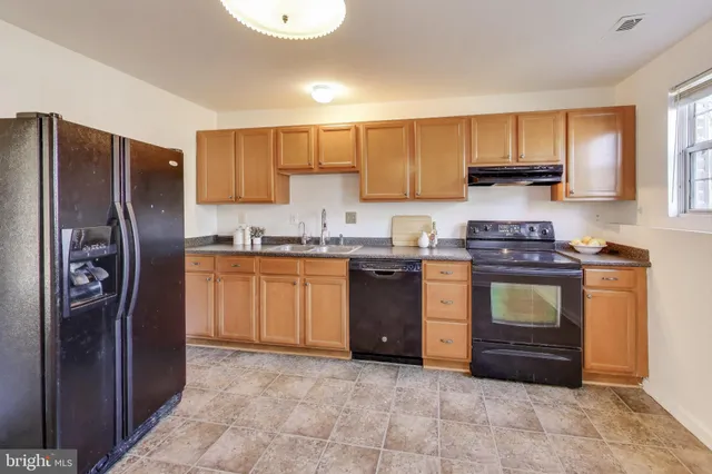 a kitchen with a refrigerator sink and cabinets