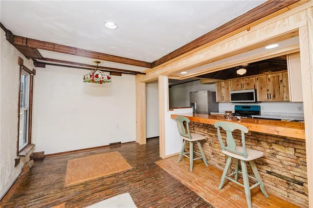 a dining hall with stainless steel appliances a stove top oven and chairs