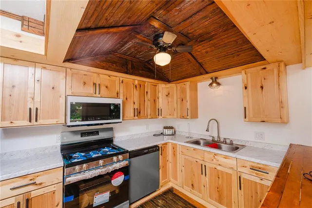 a kitchen with stainless steel appliances a stove a sink and a microwave
