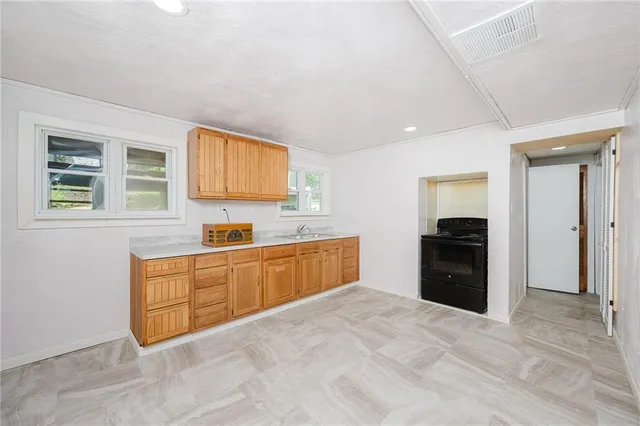 a large kitchen with stainless steel appliances granite countertop a refrigerator and a sink