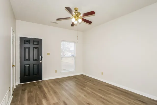 an empty room with closet and ceiling fan