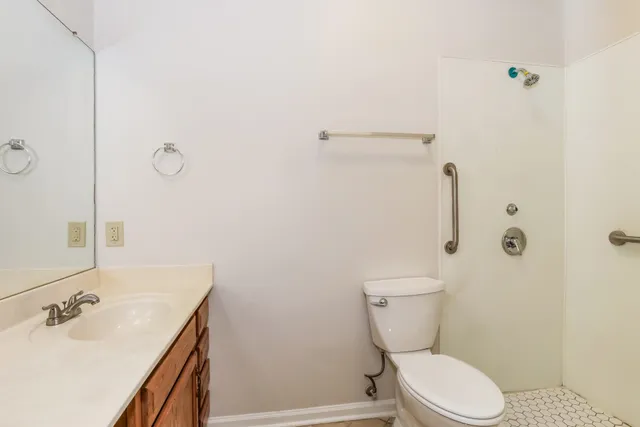a bathroom with a sink a toilet and shower
