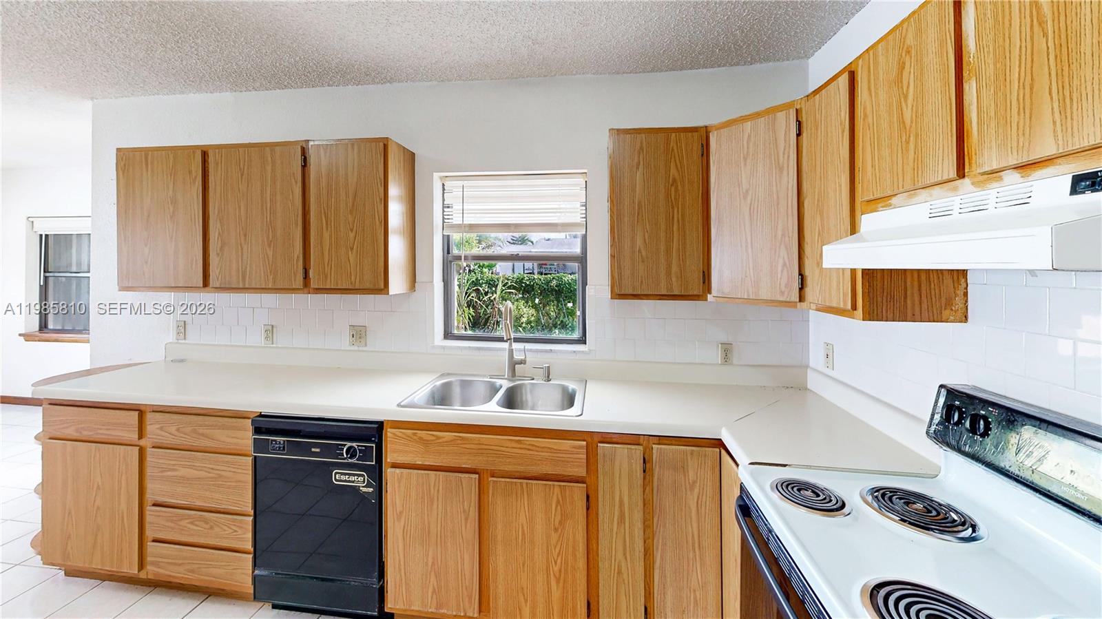 14380 Southwest 297th Street Homestead, FL 33033 - Photo 15 of 62 a kitchen with a sink a stove and cabinets