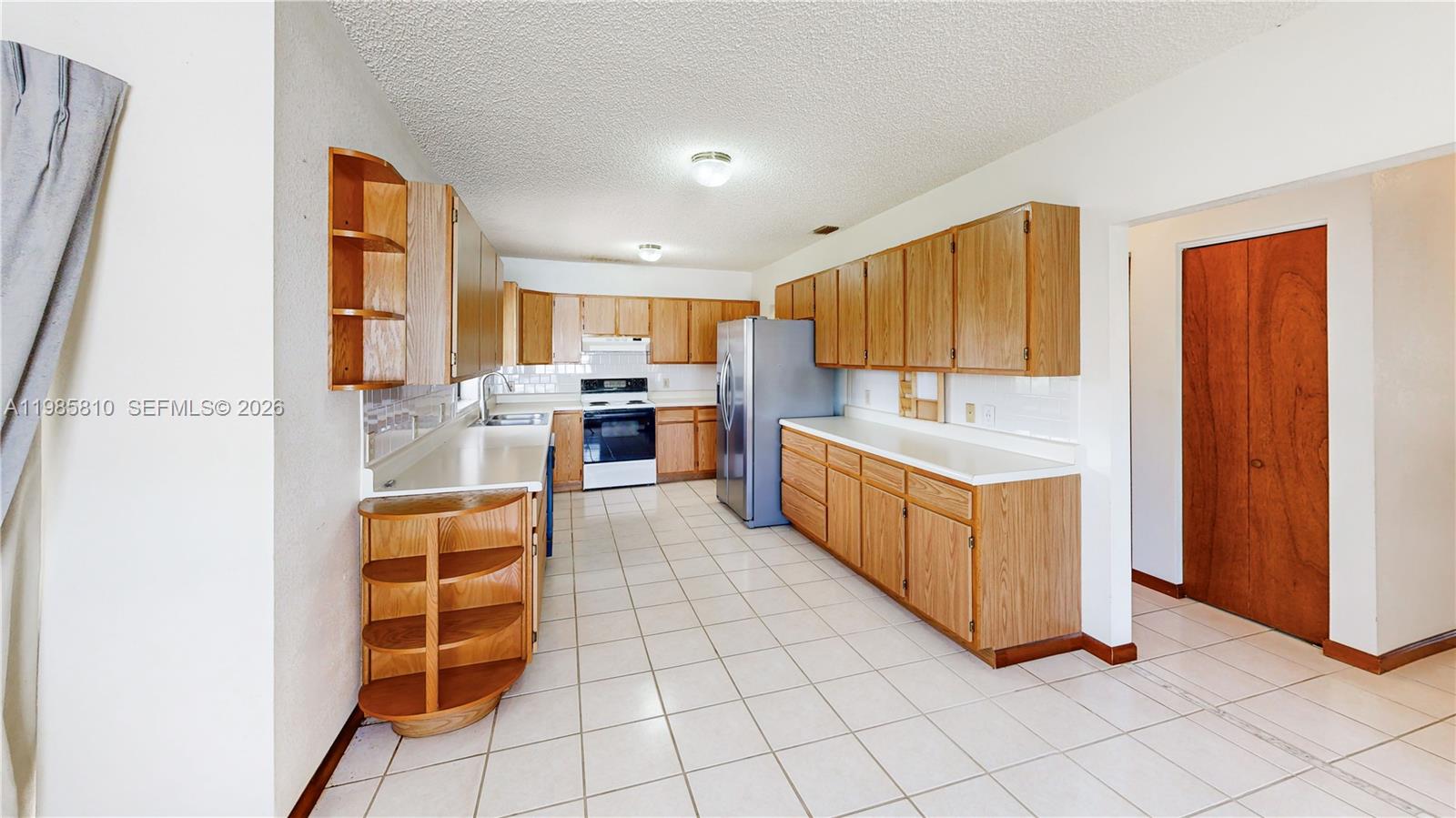 14380 Southwest 297th Street Homestead, FL 33033 - Photo 16 of 62 a kitchen with stainless steel appliances granite countertop a refrigerator and a stove top oven