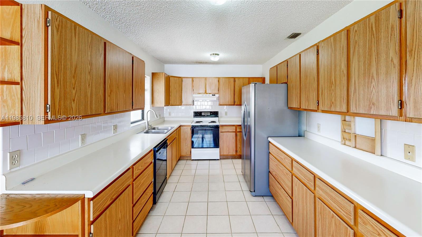 14380 Southwest 297th Street Homestead, FL 33033 - Photo 19 of 62 a kitchen with stainless steel appliances granite countertop a sink stove and refrigerator