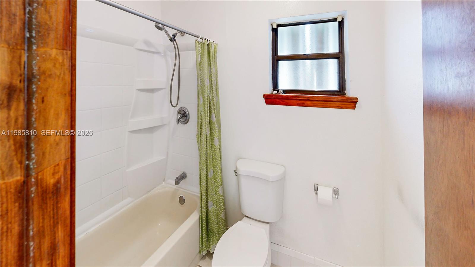 14380 Southwest 297th Street Homestead, FL 33033 - Photo 27 of 62 a bathroom with a shower a toilet and a window