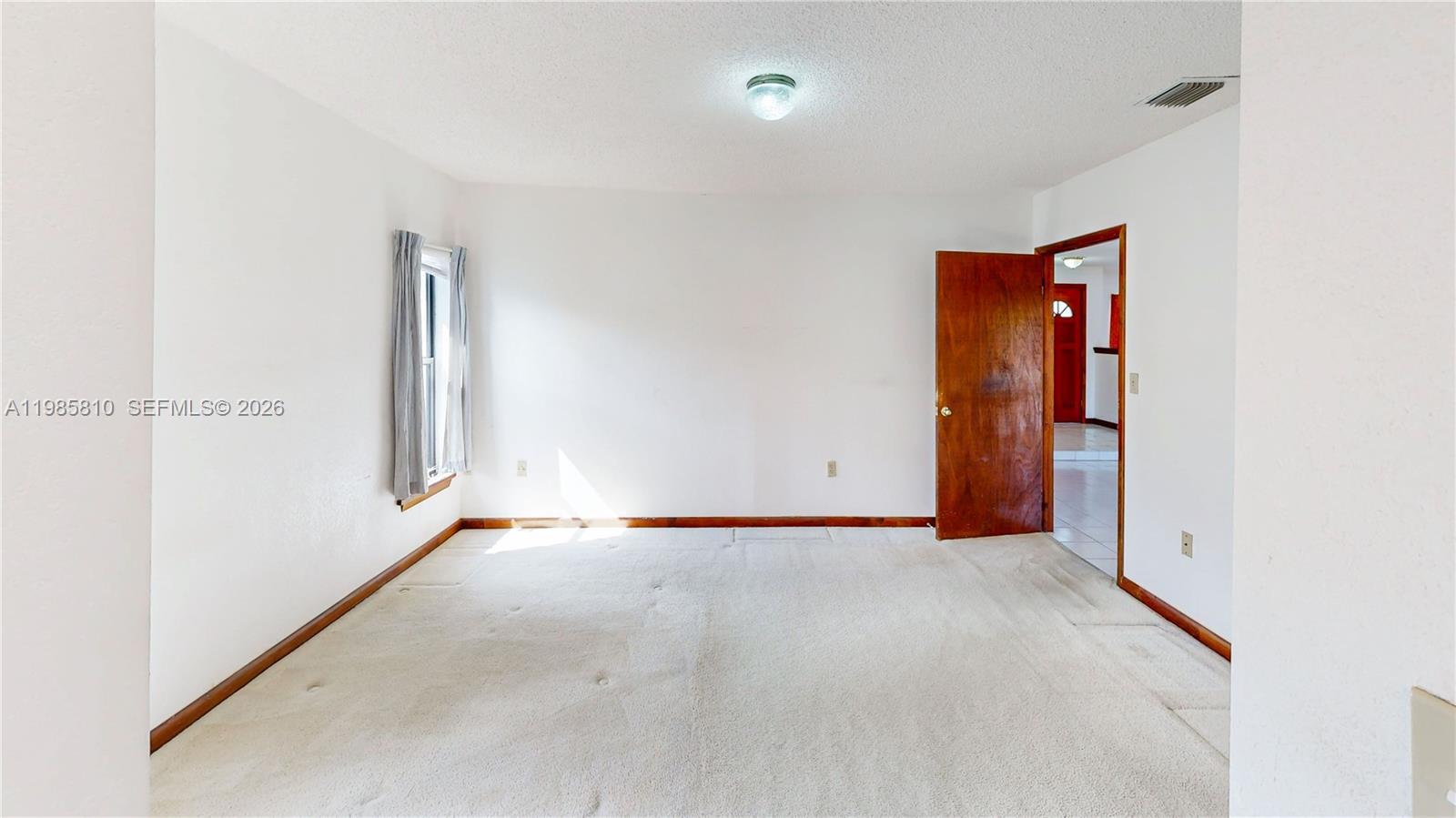 14380 Southwest 297th Street Homestead, FL 33033 - Photo 37 of 62 an empty room with an entryway and a chandelier