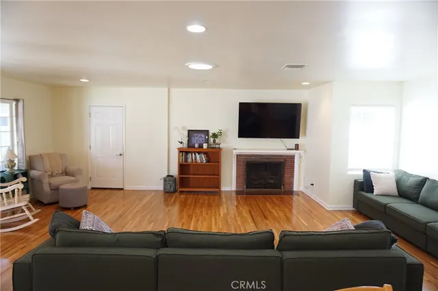 a living room with furniture a wooden floor and a large window