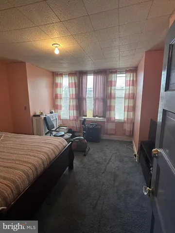 a large bedroom with a bed and large windows