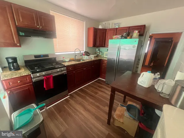 a kitchen with stainless steel appliances granite countertop a stove a refrigerator and a wooden cabinets