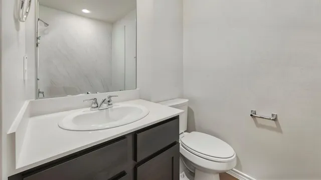 a bathroom with a sink a toilet and mirror
