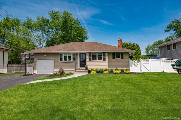 a front view of a house with a garden and trees
