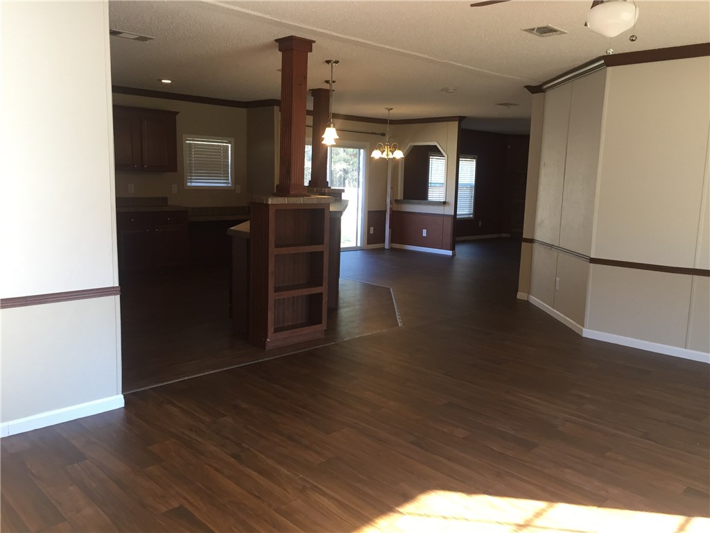 35611 Quail Road Callahan, FL 32011 - Photo 3 of 22 a view of a refrigerator in kitchen and an empty room with wooden floor