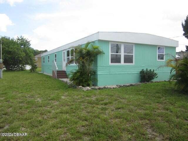 134 Douglas Street Edgewater, FL 32141 - Photo 2 of 20 a front view of a house with garden